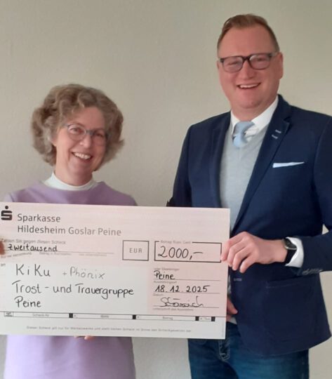 Frau Ritter und Herr Schöneich zeigen ein Check